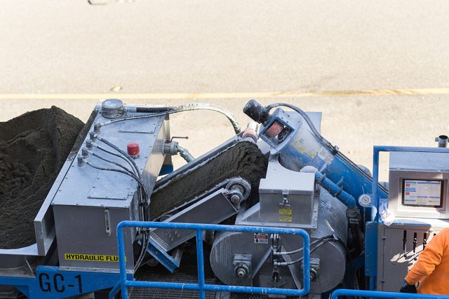 Mixer auger discharging freshly weighed gypsum concrete