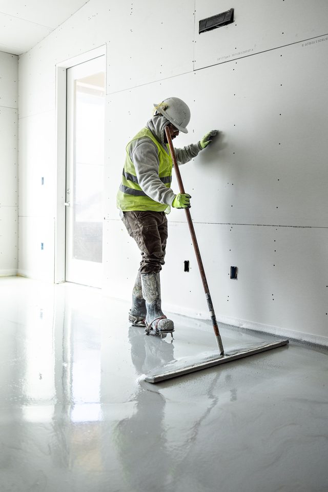 Finisher working a wet pour with a smoothing bar