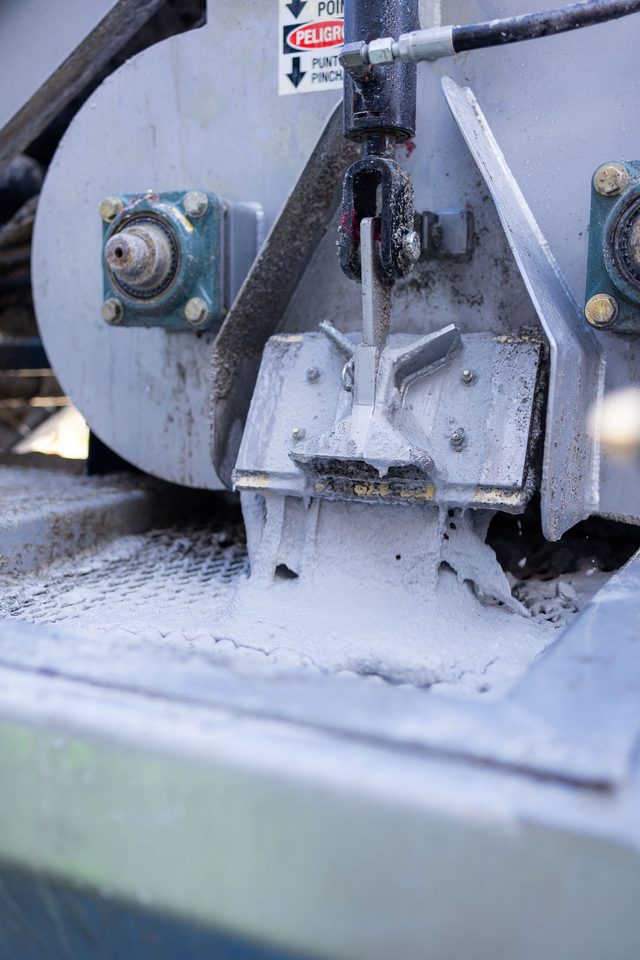 Mixer discharge gate with fresh slurry pouring through
